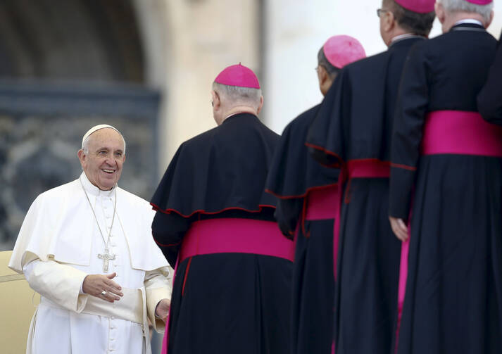Pope Francis smiles as he greets prelates during his weekly audience in St. Peter's Square at the Vatican Oct. 28. (CNS photo/Stefano Rellandini, Reuters)
