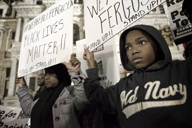 Philadelphia, PA USA - November 24, 2014; A young protester and his mother are seen holding signs at Dillworth Park at Philadelphia City Hall. (photo by Bas Slabbers/Istockphoto)